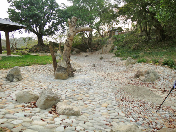 旗山鼓山公園原有各色卵石經重新舖排後展現曲流意象。（圖∕張筧 攝）