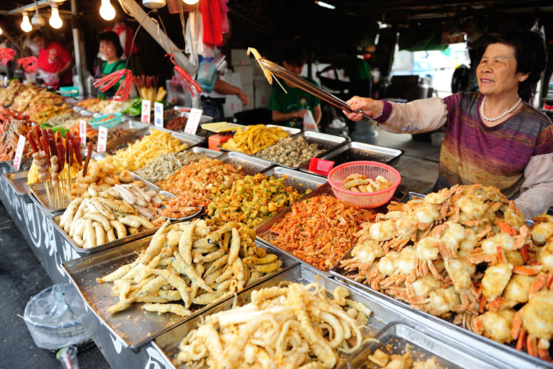興達港的海鮮炸物琳瑯滿目，店家皆大方讓遊客試吃。（圖∕李士豪　攝）