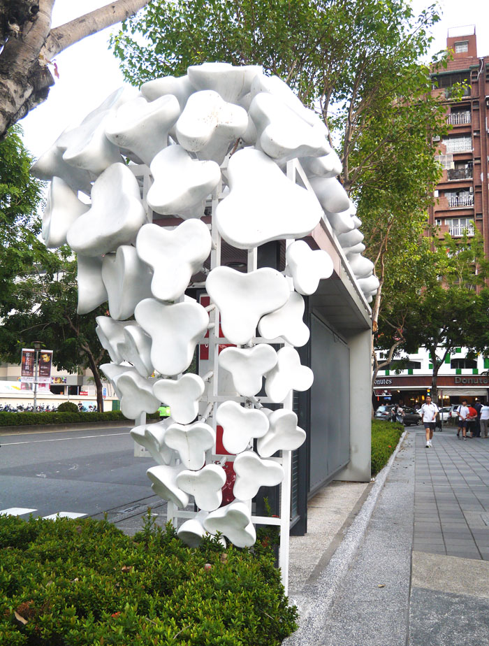 高雄市文化中心周遭分布六座創意候車亭，以寫意白色花朵為造型的候車亭位處文化中心東側。（圖∕李昀諭　攝）