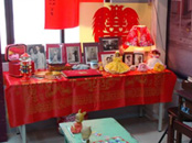大紅色的桌巾，充滿喜氣，桌上放滿新人結婚照，在物資缺乏的年代，簡單隆重。(圖/郭力睿攝)