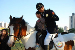 騎警隊的帥哥，親切的扶著小朋友體驗馬上風情。（圖/港都騎警隊提供）