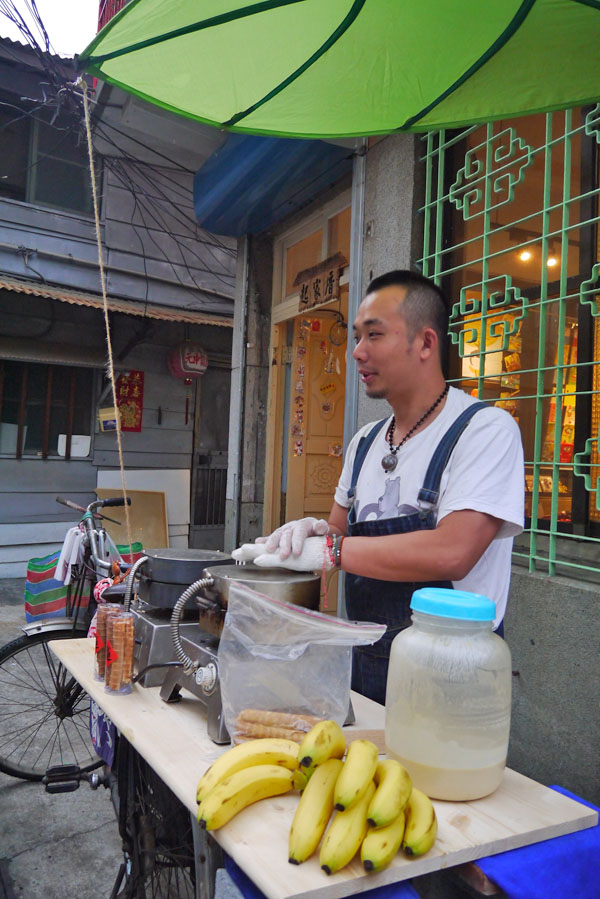 張廣德在「起家厝」前擺攤賣旗山香蕉煎餅。（圖∕李昀諭 攝）