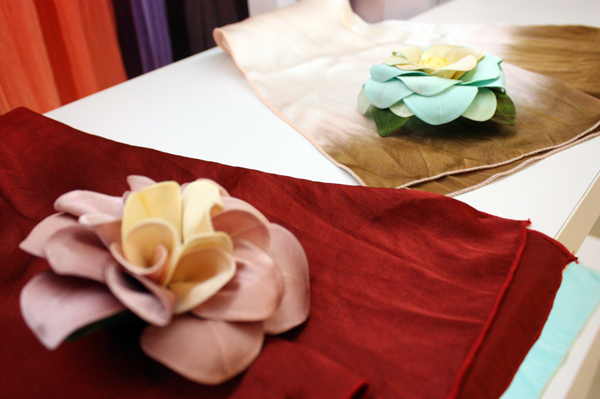 首創以絲織布為素材，設計製成台灣客家的夜合花與油桐花胸針飾品。(圖/劉尹淳攝)