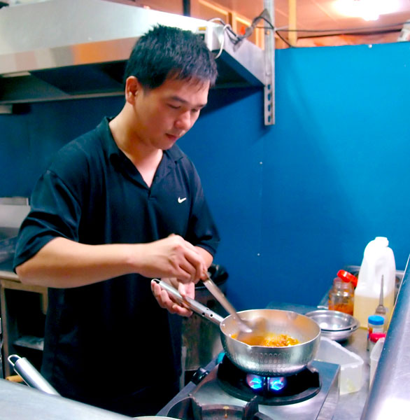 老闆林駿恆專注地為客人烹調拿手料理。（圖/曾千純 攝）