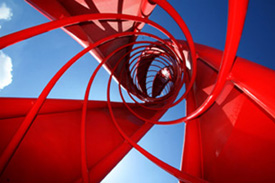 主入口標誌塔則為伊東豊雄的作品「火焰」，呼應主場館的螺旋延伸律動，紅色象徵活耀的生命力。(圖/黃昱貴攝)