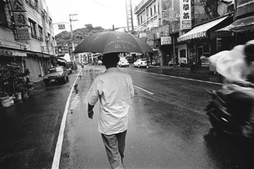 葉老漫步在雨中的左營勝利路。(圖/國立台灣文學館提供，林柏樑攝影)