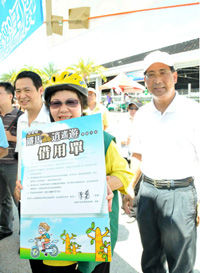 陳市長拿著借用單的海報，呼籲市民能多利用公共腳踏車，一起來節能減碳。（圖/高嘉澤攝）