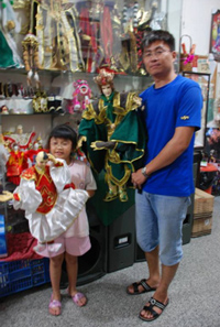 陳皇寶（右）放棄職棒夢，傳承家族掌中戲事業，他的寶貝女兒也有模有樣，還跟父親一起到蒙古去表演過。（郭力睿攝）