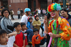 小丑在「O2深呼吸 我愛鹽埕區」活動現場摺氣球送給小朋友，聚集不少人潮。（圖/郭力睿攝）