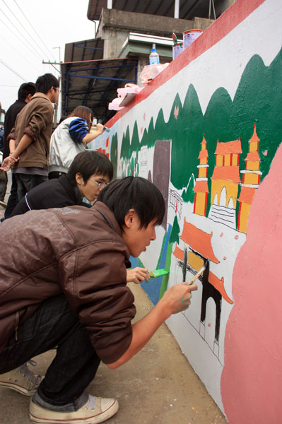 中山大學社團學生在泥牆畫出美濃在地的生活藝術。(圖/熊宏輝攝)