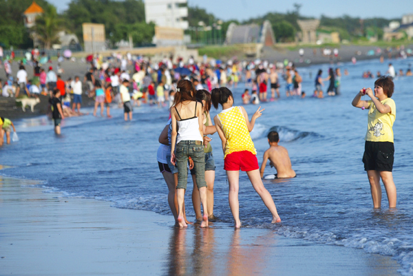 夏天的高雄，遊客愛到海邊消暑戲水。(圖/蔡明余攝)